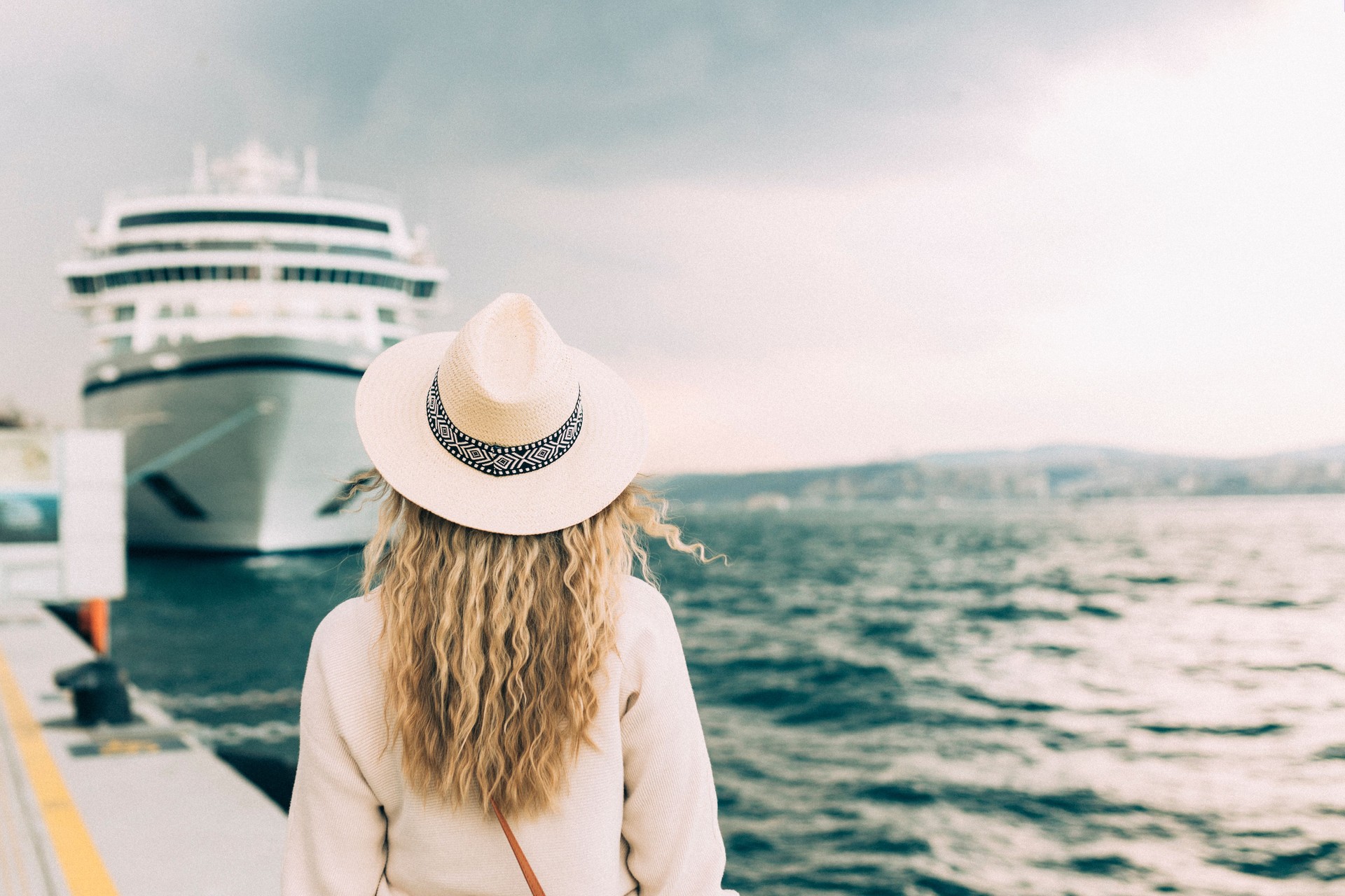 Mujer turista parada frente a un gran crucero, mujer de viaje